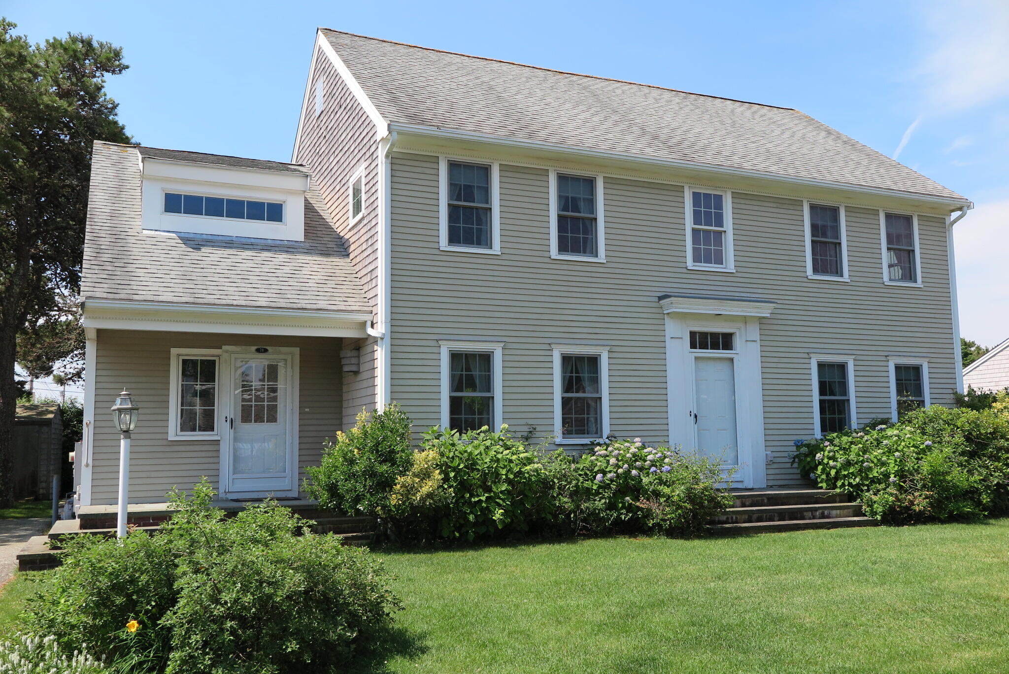 79 Shore Road West Dennis, MA 02670 - Photo 1 of 42 a front view of a house with a yard