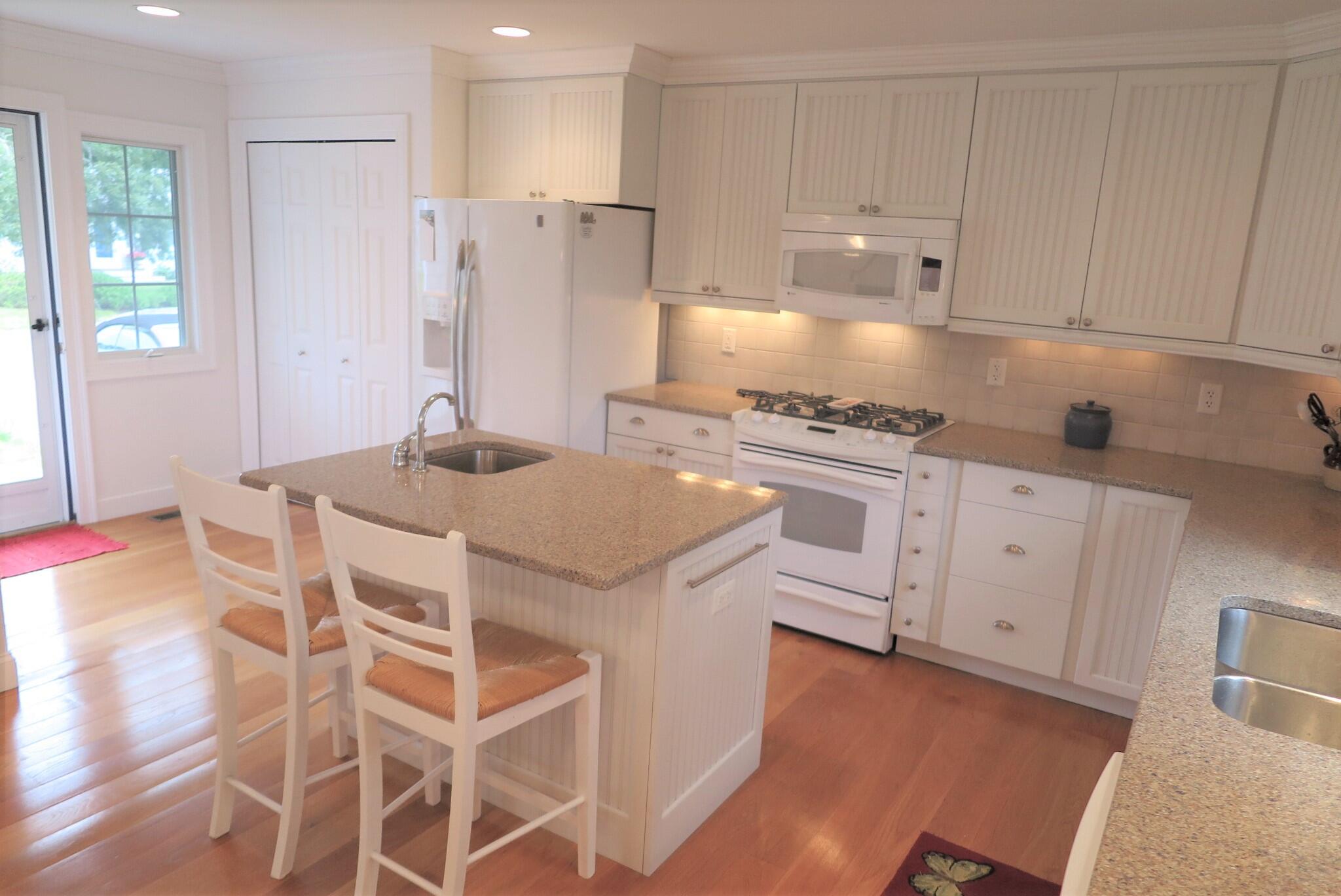 79 Shore Road West Dennis, MA 02670 - Photo 14 of 42 a kitchen with white cabinets and stainless steel appliances