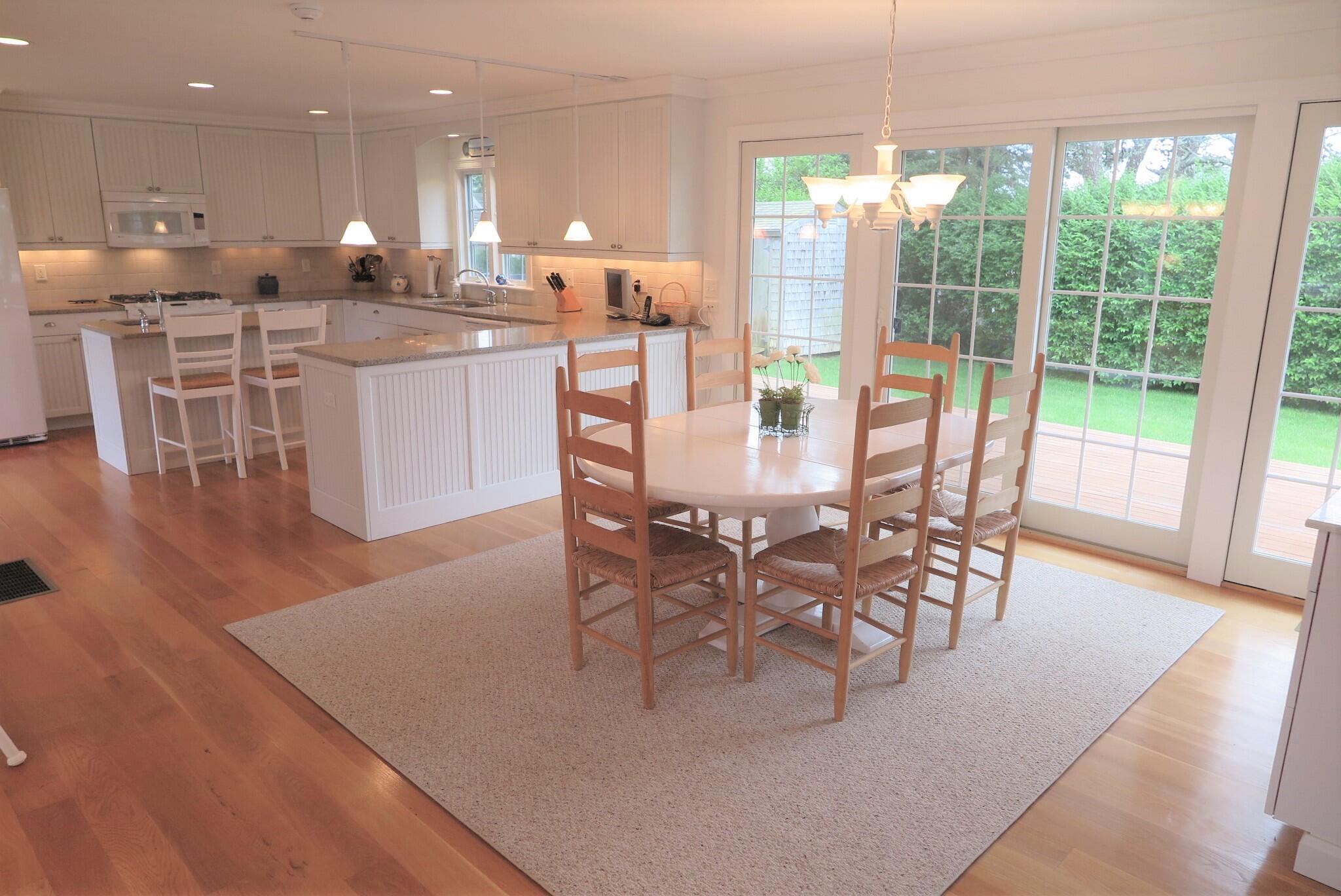79 Shore Road West Dennis, MA 02670 - Photo 15 of 42 a dining hall with stainless steel appliances a dining table wooden floor and a large window