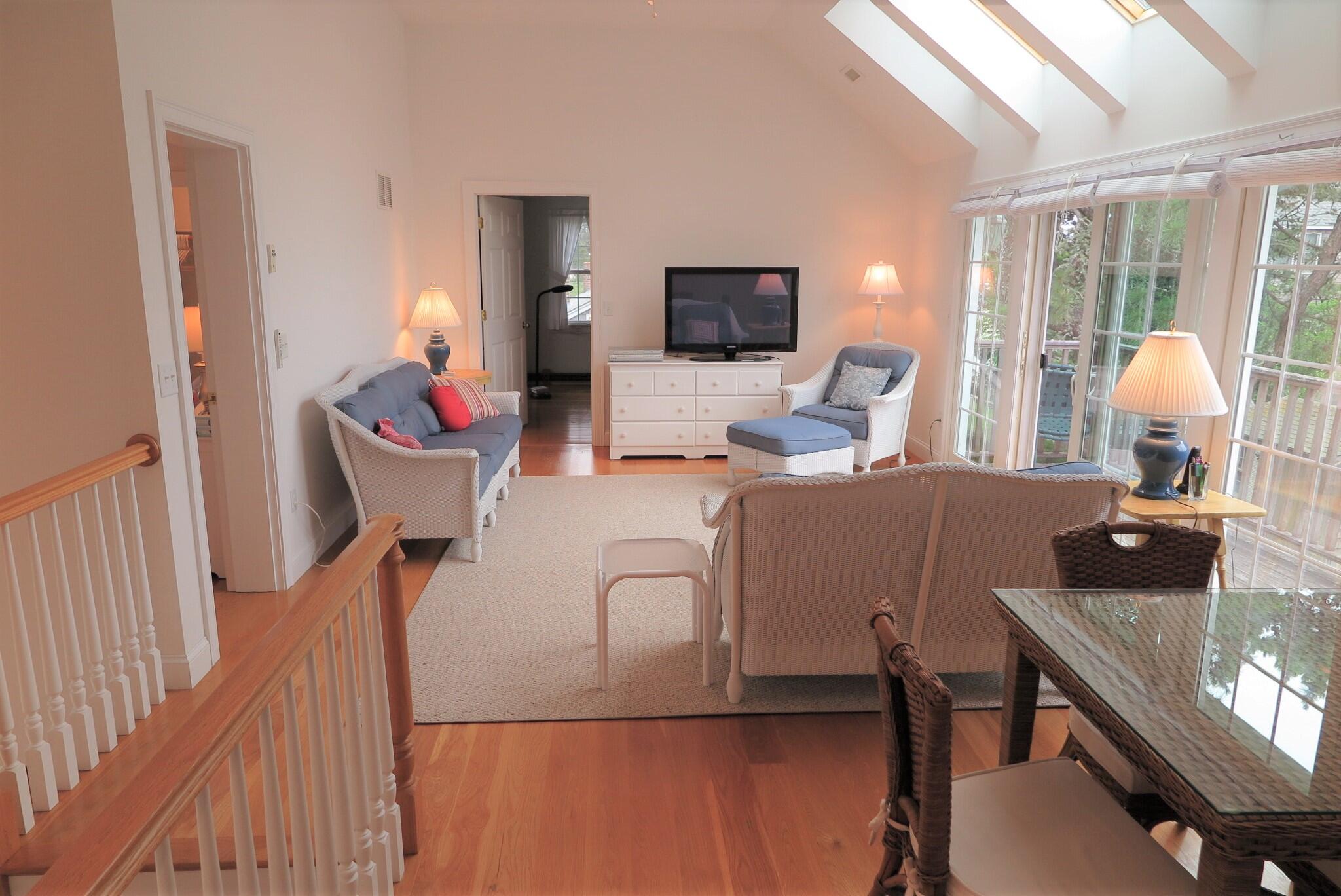 79 Shore Road West Dennis, MA 02670 - Photo 20 of 42 a living room with furniture a flat screen tv and a large window
