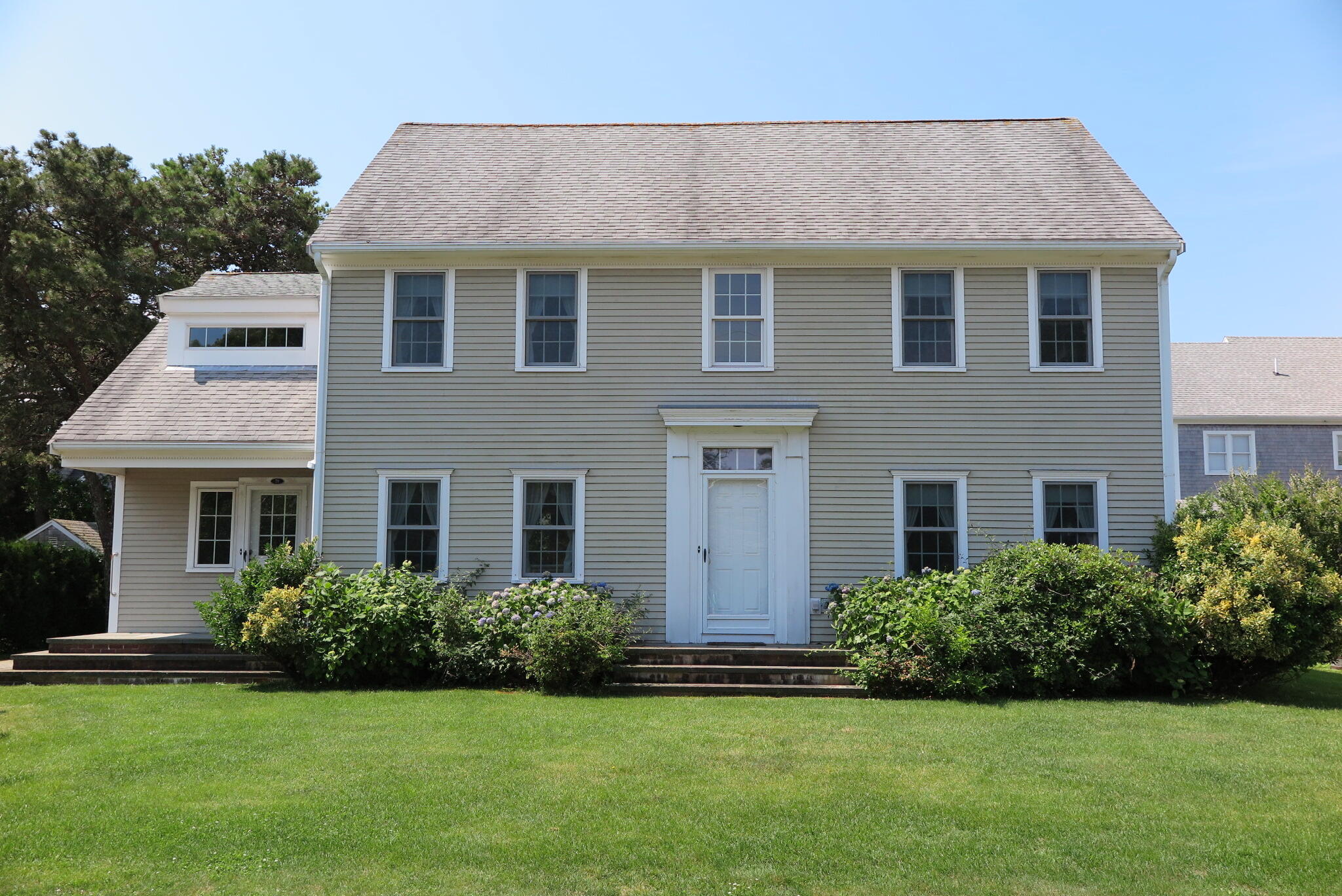 79 Shore Road West Dennis, MA 02670 - Photo 2 of 42 a front view of a house with a garden