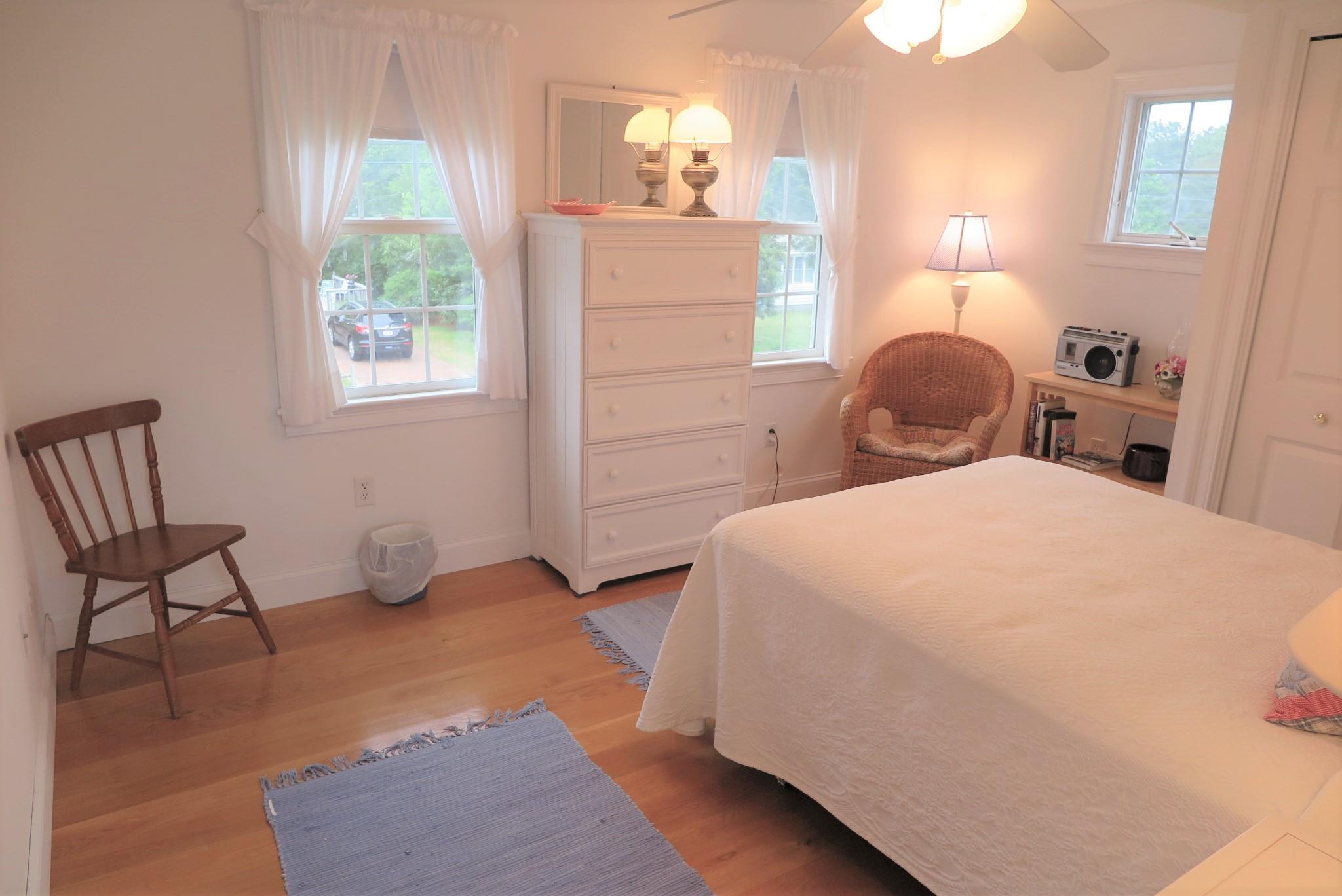 79 Shore Road West Dennis, MA 02670 - Photo 32 of 42 a bedroom with a bed and a chair