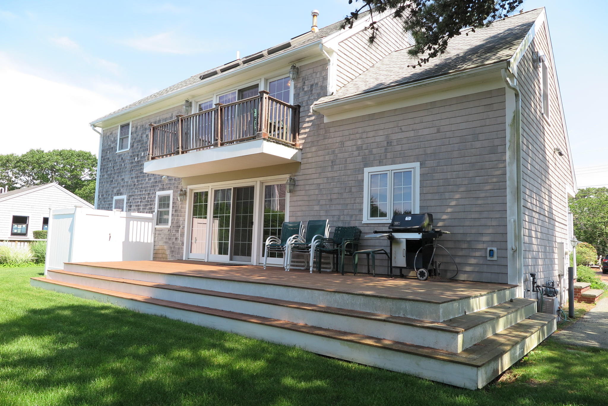 79 Shore Road West Dennis, MA 02670 - Photo 39 of 42 a front view of a house with a yard table and chairs