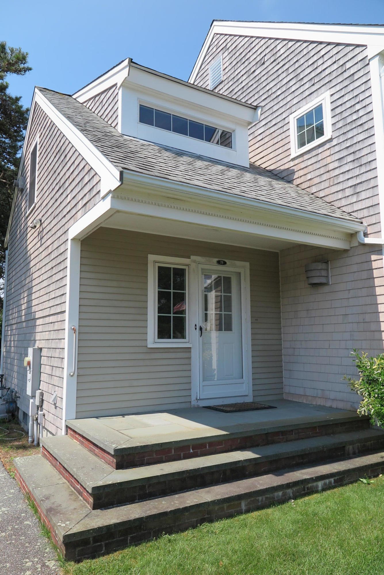79 Shore Road West Dennis, MA 02670 - Photo 4 of 42 a front view of a house with a garden