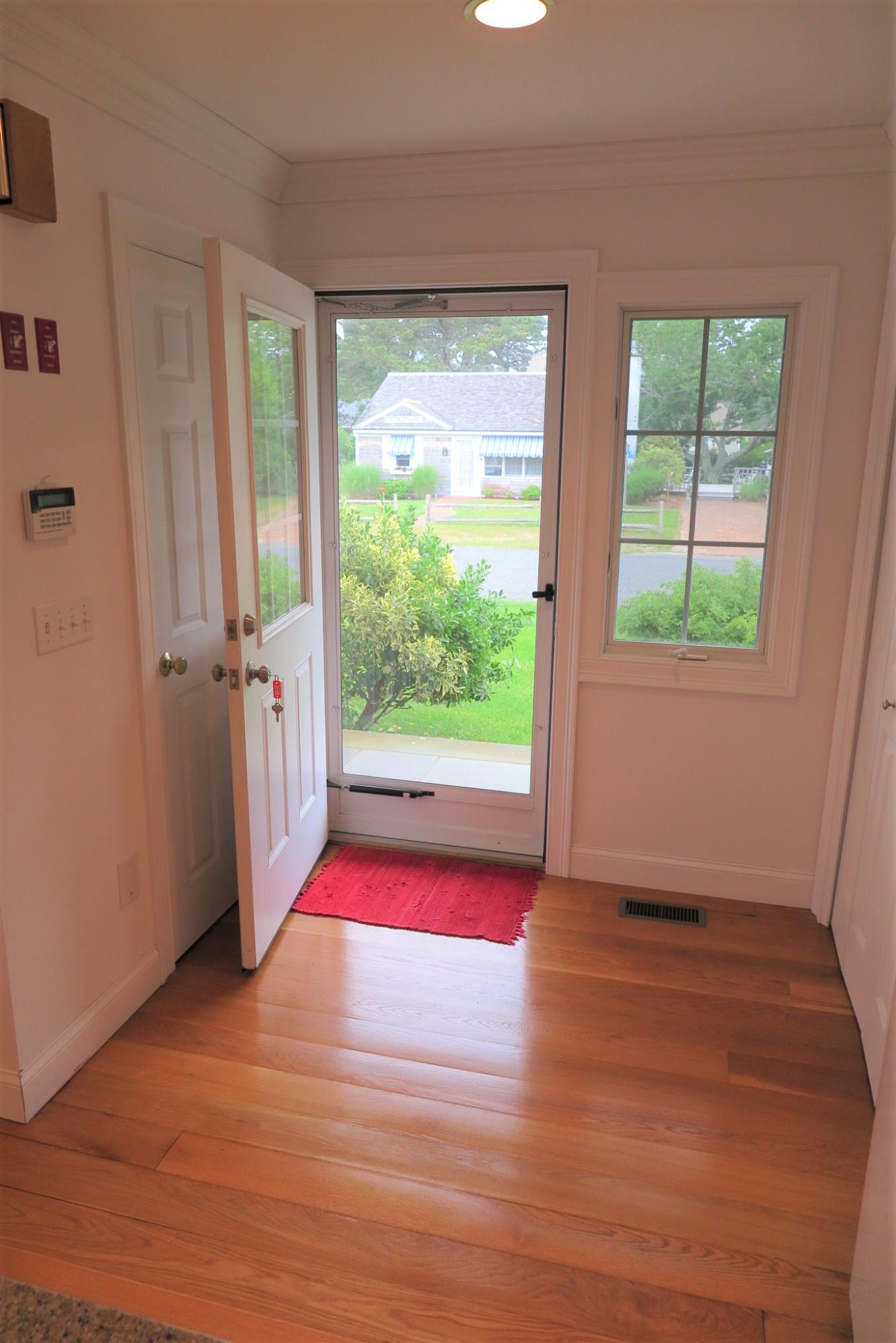 79 Shore Road West Dennis, MA 02670 - Photo 7 of 42 an empty room with wooden floor and windows