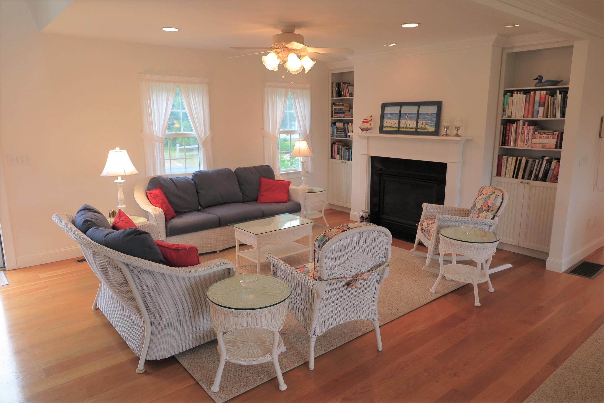 79 Shore Road West Dennis, MA 02670 - Photo 9 of 42 a living room with furniture a lamp and a fireplace