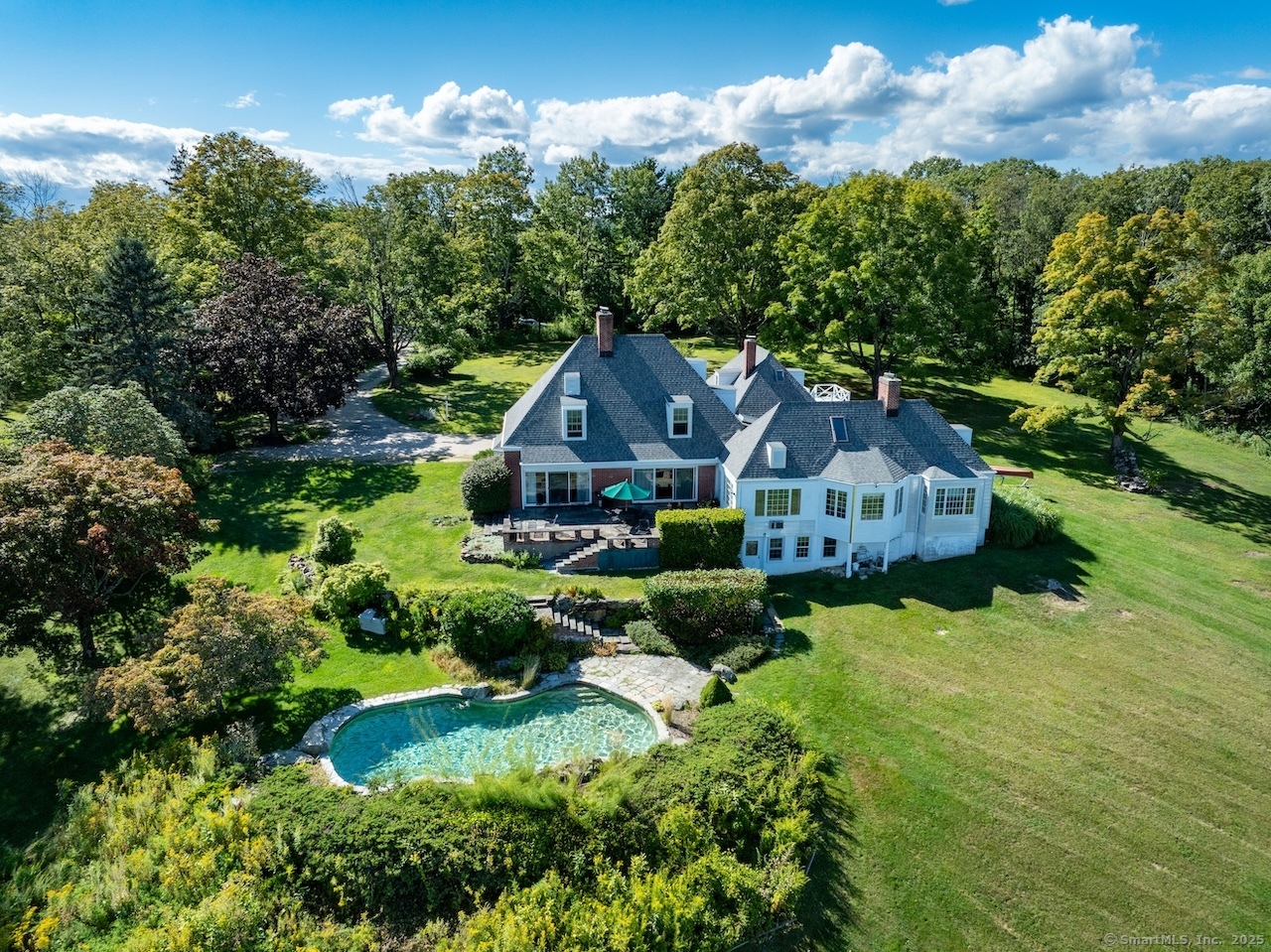 a aerial view of a house with a big yard plants and large trees