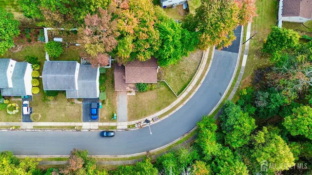an aerial view of residential house with outdoor space and trees all around