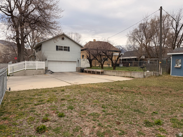 110 South 200 East Springville, UT 84663 - Photo 23 of 23 View of yard featuring an attached garage and concrete driveway
