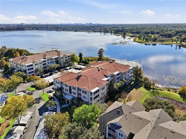 an aerial view of a house with outdoor space and lake view in back