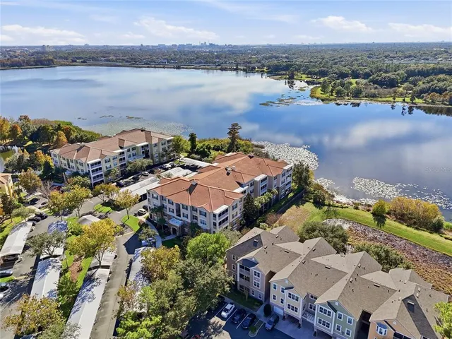 an aerial view of ocean and residential houses with outdoor space