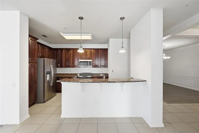 a kitchen with stainless steel appliances granite countertop a refrigerator a sink and a stove