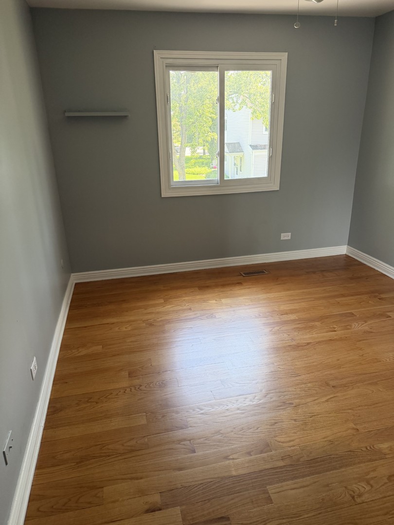606 Bridgeport Place Wheeling, IL 60090 - Photo 9 of 25 an empty room with wooden floor and windows