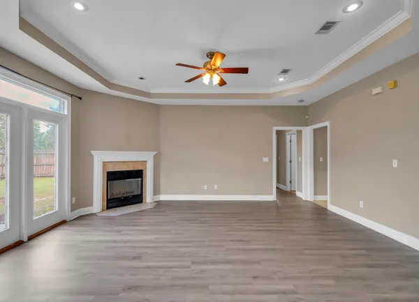 a view of an empty room with a window and fireplace