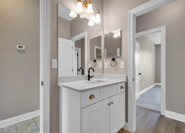 a view of bathroom with a sink and mirror
