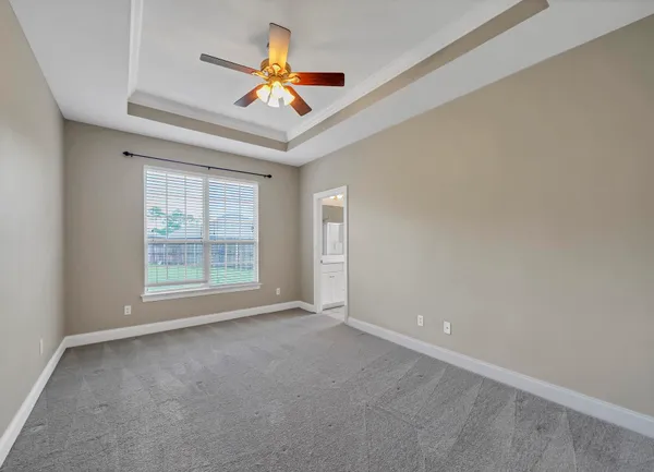 an empty room with a ceiling fan and window
