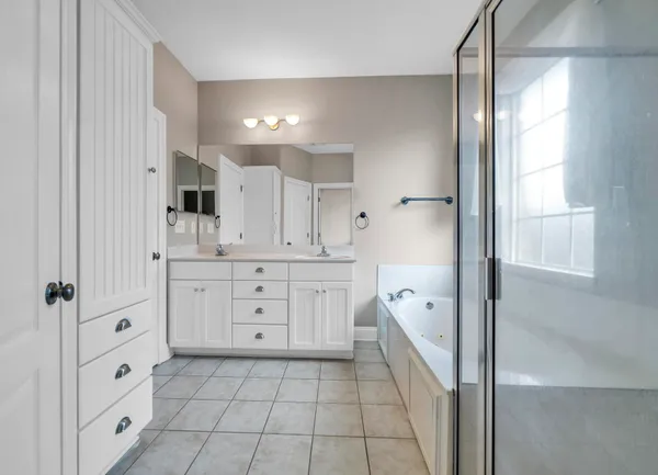 a kitchen with white cabinets and window