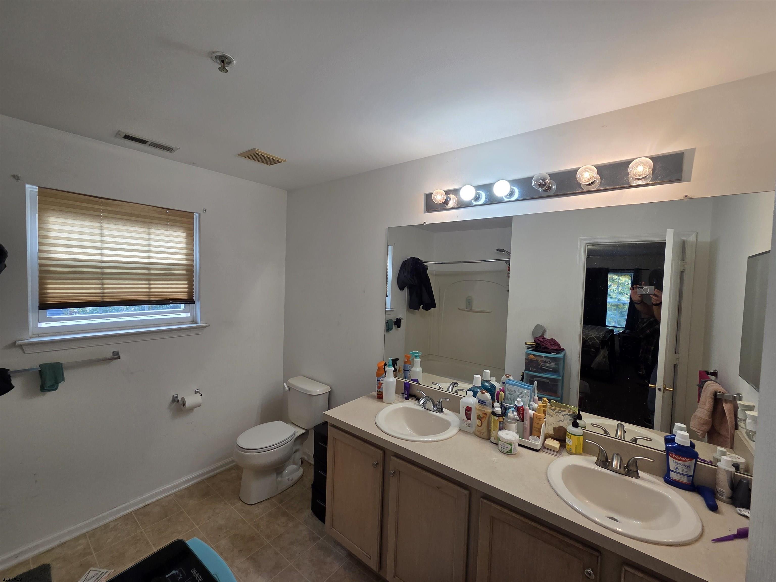 148 Natalie Road, Unit 148 Riverside, NJ 08075 - Photo 15 of 18 a bathroom with a double vanity sink toilet and mirror