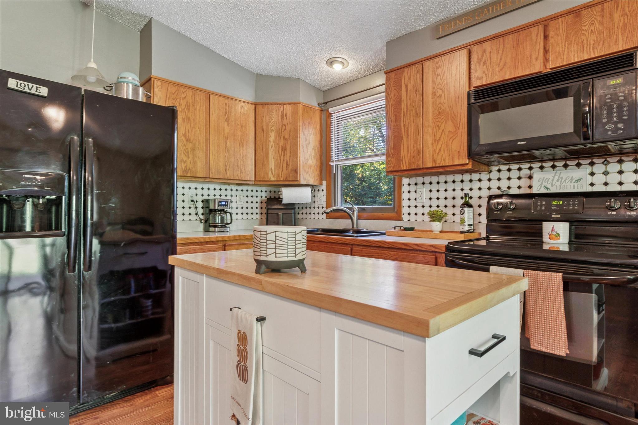 105 Cambridge Road Coatesville, PA 19320 - Photo 3 of 21 a kitchen with stainless steel appliances a sink a stove and a microwave