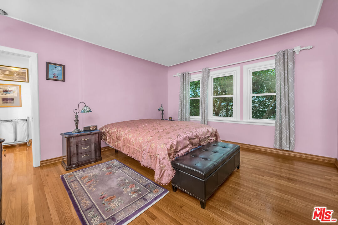 1163 Hi Point Street Los Angeles, CA 90035 - Photo 12 of 29 a spacious bedroom with a bed dresser and wooden floor