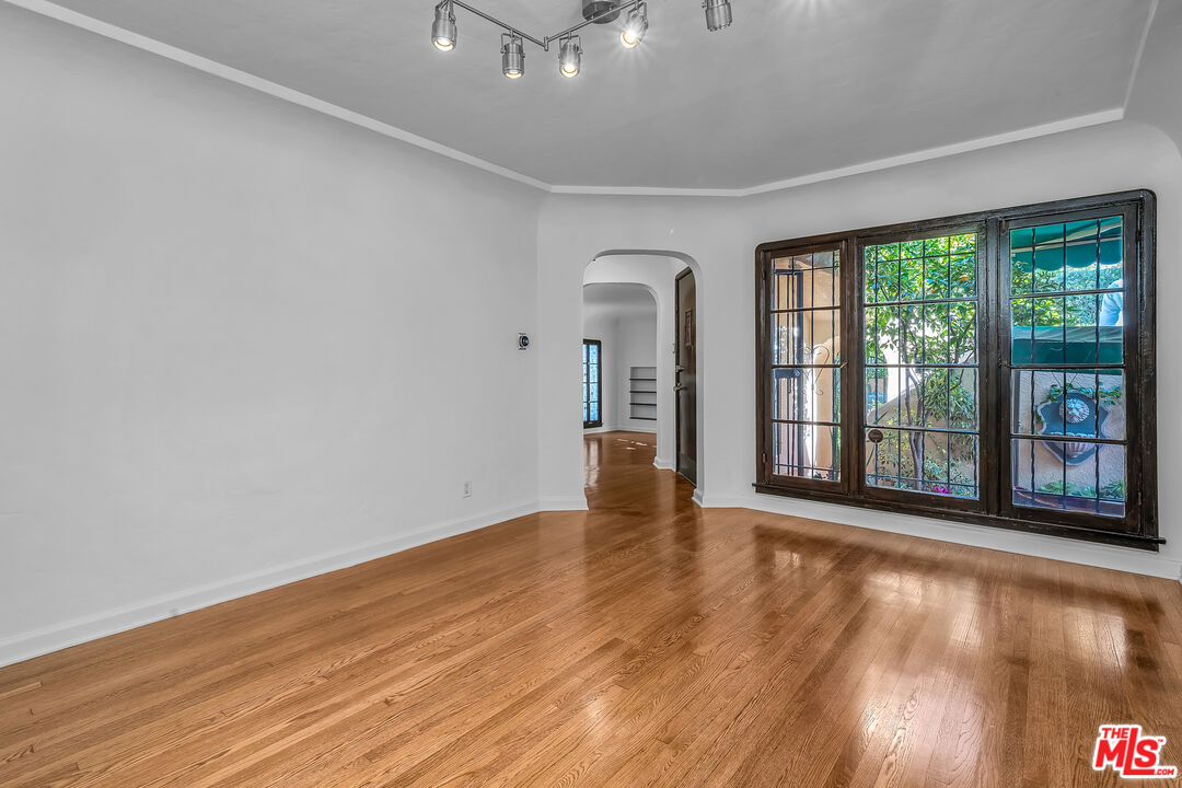 1163 Hi Point Street Los Angeles, CA 90035 - Photo 16 of 29 wooden floor in an empty room with a window