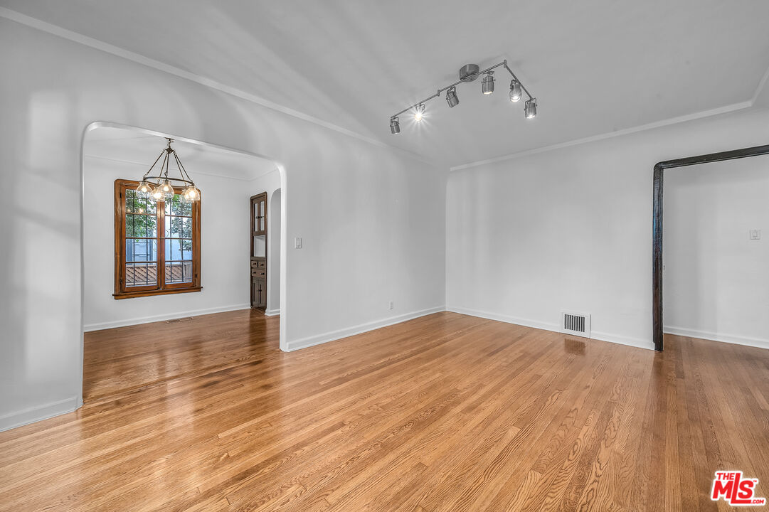 1163 Hi Point Street Los Angeles, CA 90035 - Photo 17 of 29 a view of an empty room with wooden floor and a window