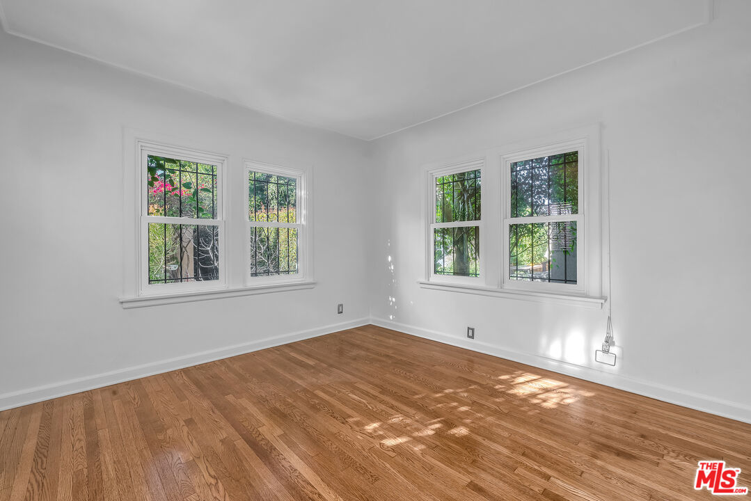 1163 Hi Point Street Los Angeles, CA 90035 - Photo 18 of 29 a view of an empty room with wooden floor and a window