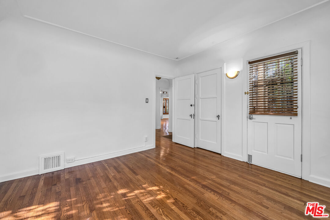 1163 Hi Point Street Los Angeles, CA 90035 - Photo 19 of 29 a view of empty room with wooden floor and fan