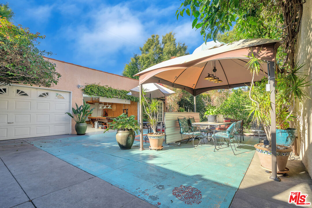 1163 Hi Point Street Los Angeles, CA 90035 - Photo 24 of 29 a view of a patio with table and chairs under an umbrella
