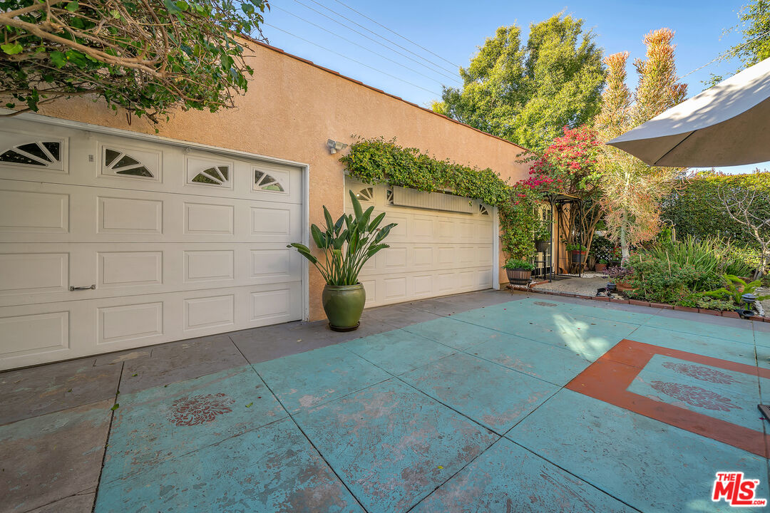 1163 Hi Point Street Los Angeles, CA 90035 - Photo 25 of 29 a backyard of a house with potted plants and large tree