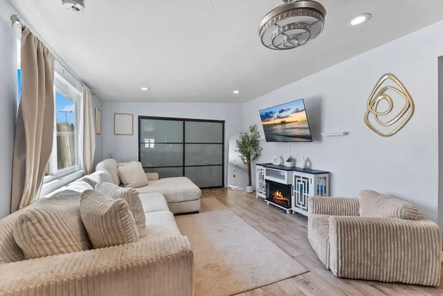 a living room with furniture a fireplace and a flat screen tv