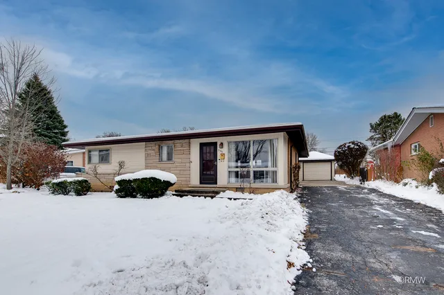 a front view of a house with a yard covered in snow