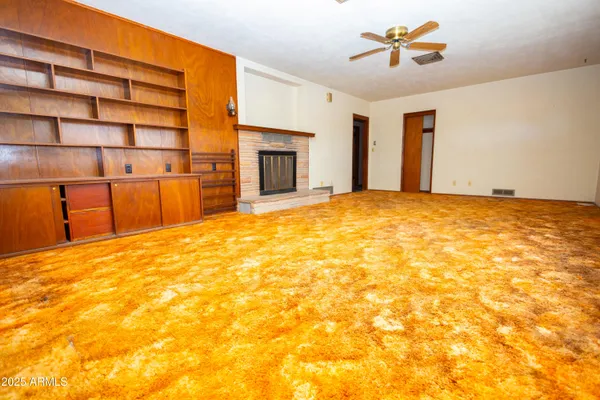 a view of an empty room with a fireplace and a window