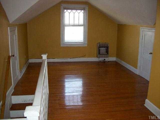 111 Academy Street Roxboro, NC 27573 - Photo 8 of 12 a view of an empty room with wooden floor and a window