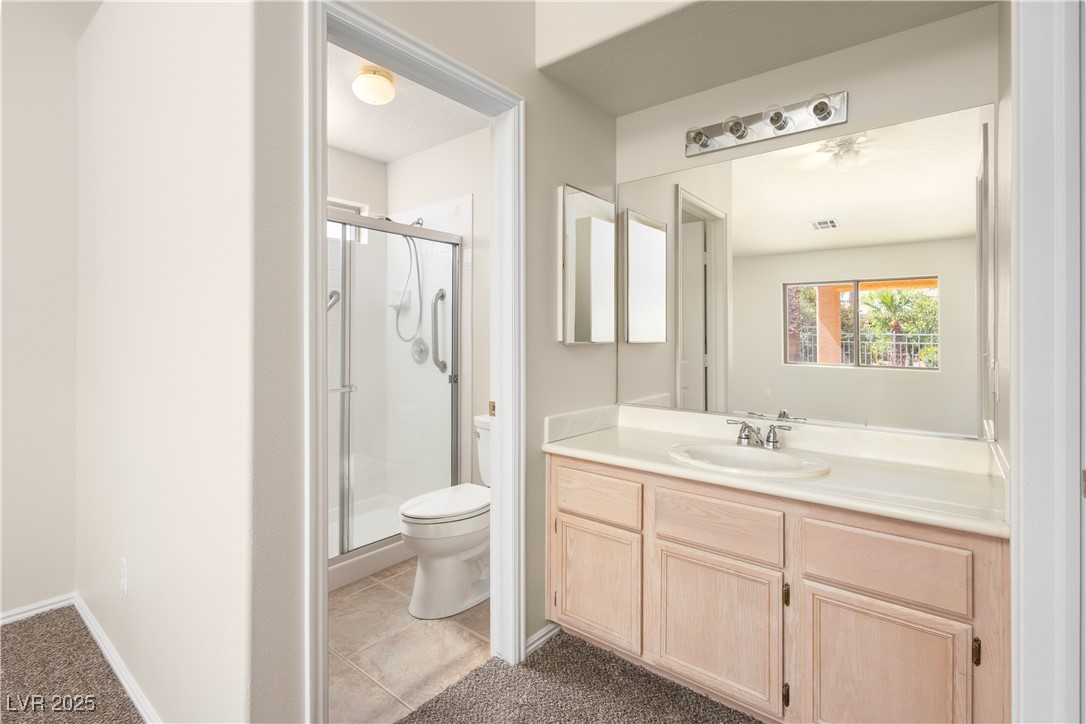 490 Ruby Drive Mesquite, NV 89027 - Photo 11 of 23 Full bath with vanity, a shower stall, and dark tile patterned flooring