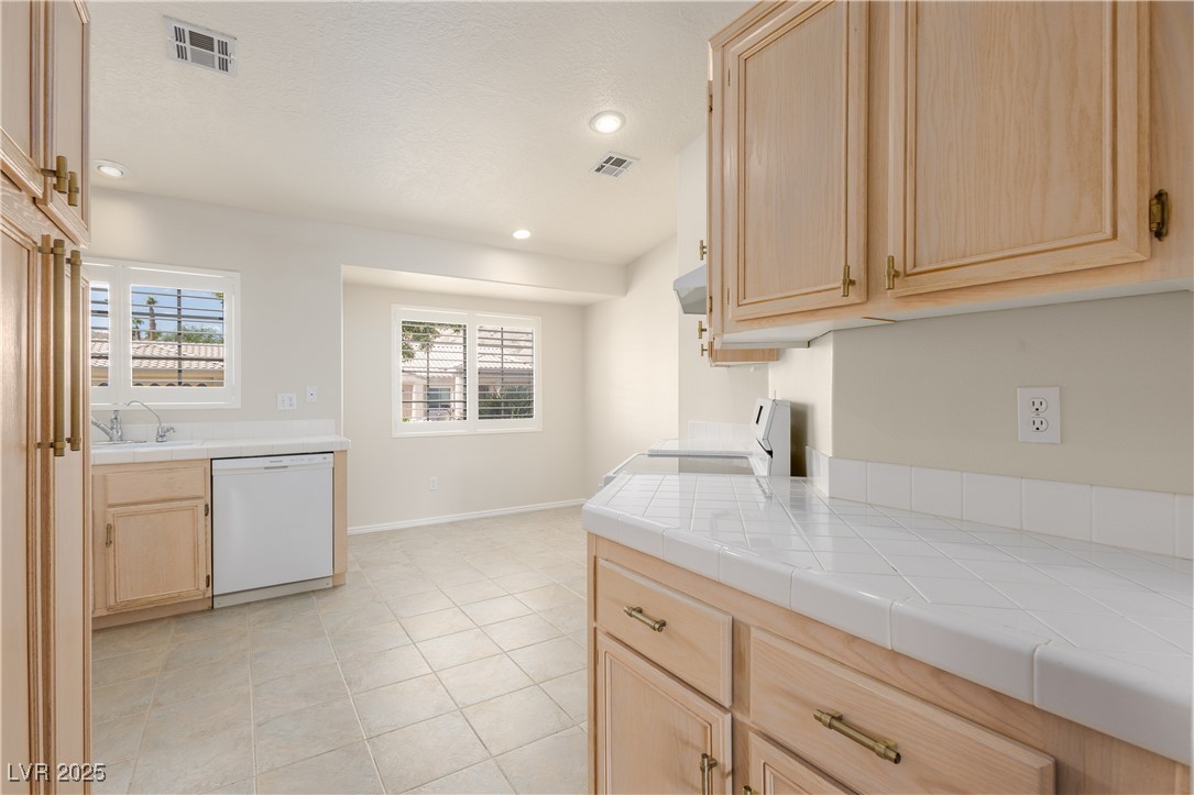 490 Ruby Drive Mesquite, NV 89027 - Photo 13 of 23 Kitchen featuring light brown cabinetry, tile countertops, recessed lighting, white appliances, and light tile patterned floors