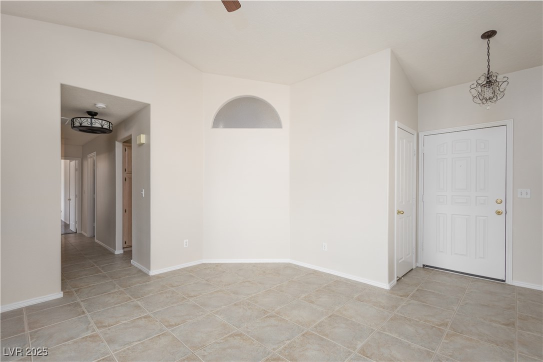 490 Ruby Drive Mesquite, NV 89027 - Photo 6 of 23 Unfurnished room with a chandelier, light tile patterned flooring, lofted ceiling, and ceiling fan