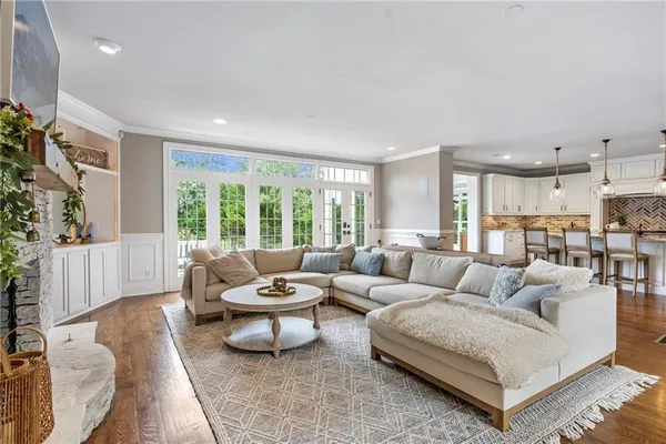 a view of a dining room and livingroom with furniture wooden floor a chandelier