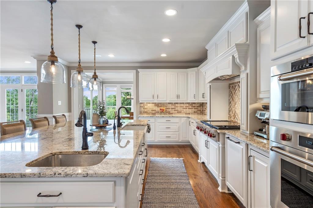 6026 GC Crow Road Flowery Branch, GA 30542 - Photo 17 of 100 a kitchen with stainless steel appliances granite countertop a stove a sink and a refrigerator