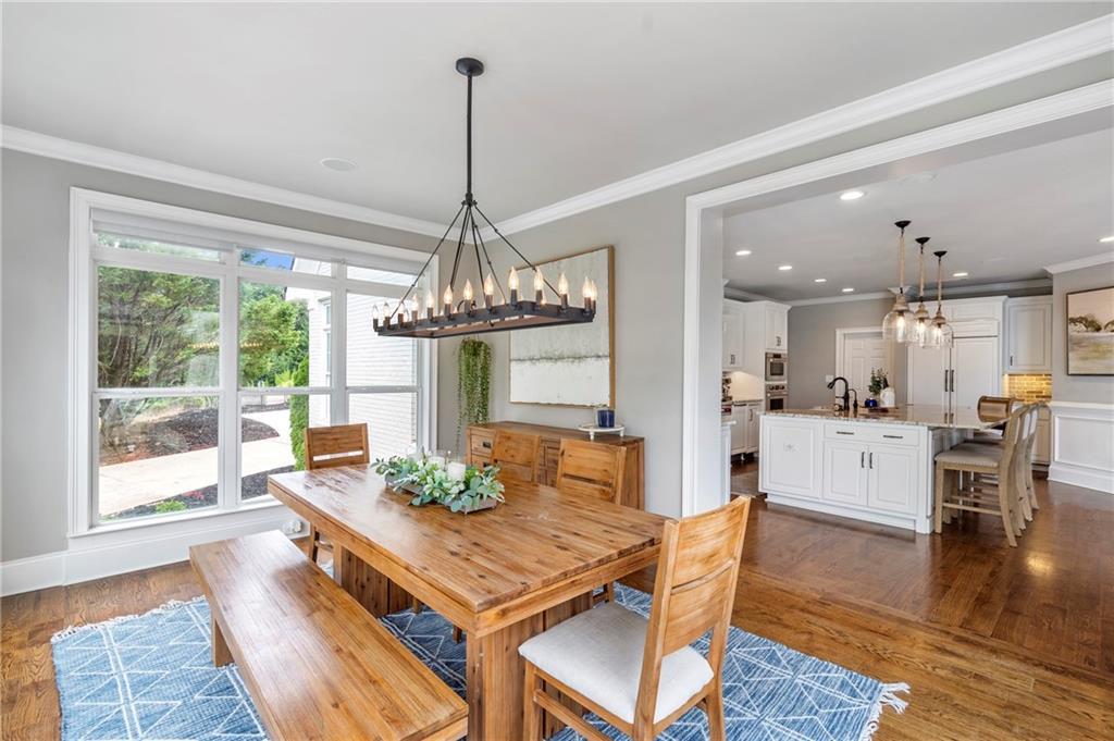 6026 GC Crow Road Flowery Branch, GA 30542 - Photo 19 of 100 a view of a dining room and livingroom with furniture wooden floor a chandelier