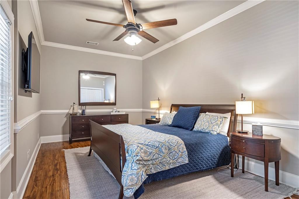 6026 GC Crow Road Flowery Branch, GA 30542 - Photo 46 of 100 a bedroom with a large bed and a chandelier