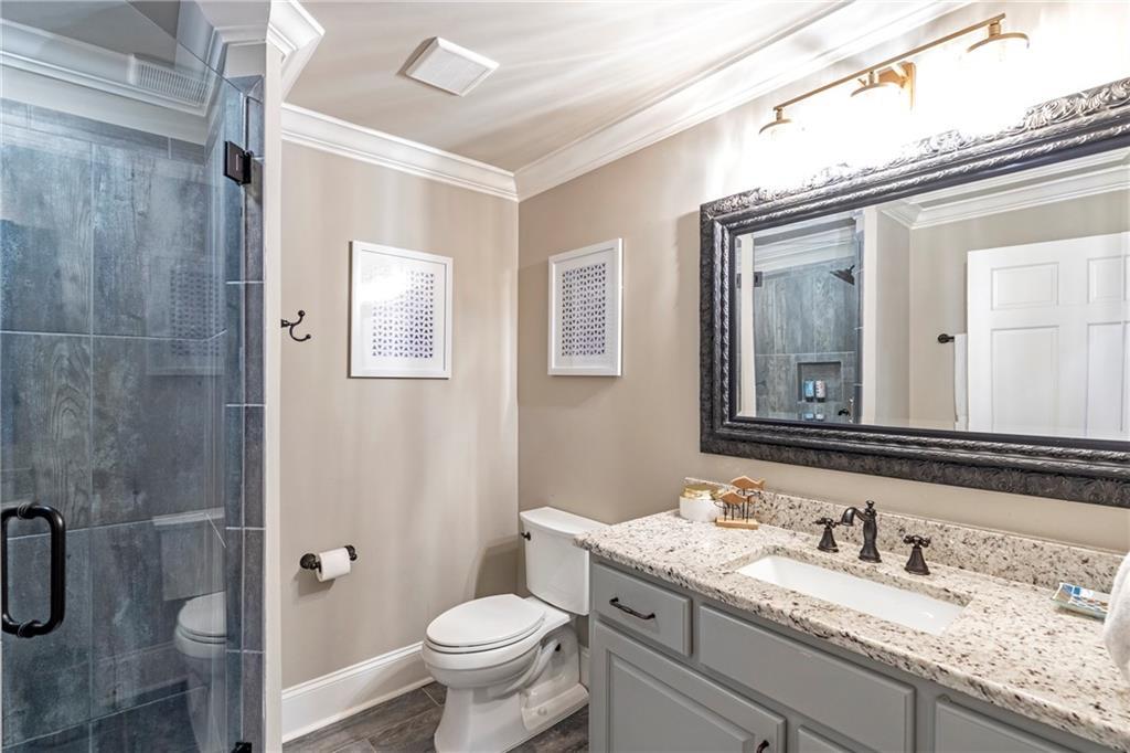 6026 GC Crow Road Flowery Branch, GA 30542 - Photo 48 of 100 a bathroom with a granite countertop sink toilet and shower
