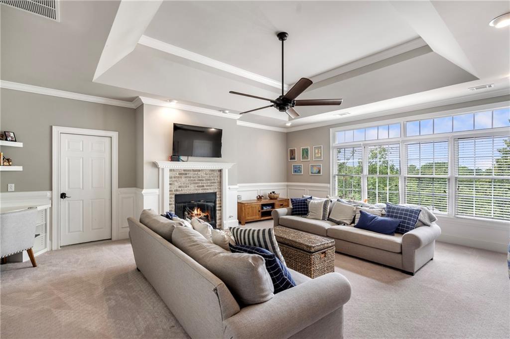 6026 GC Crow Road Flowery Branch, GA 30542 - Photo 60 of 100 a living room with furniture a fireplace and a flat screen tv