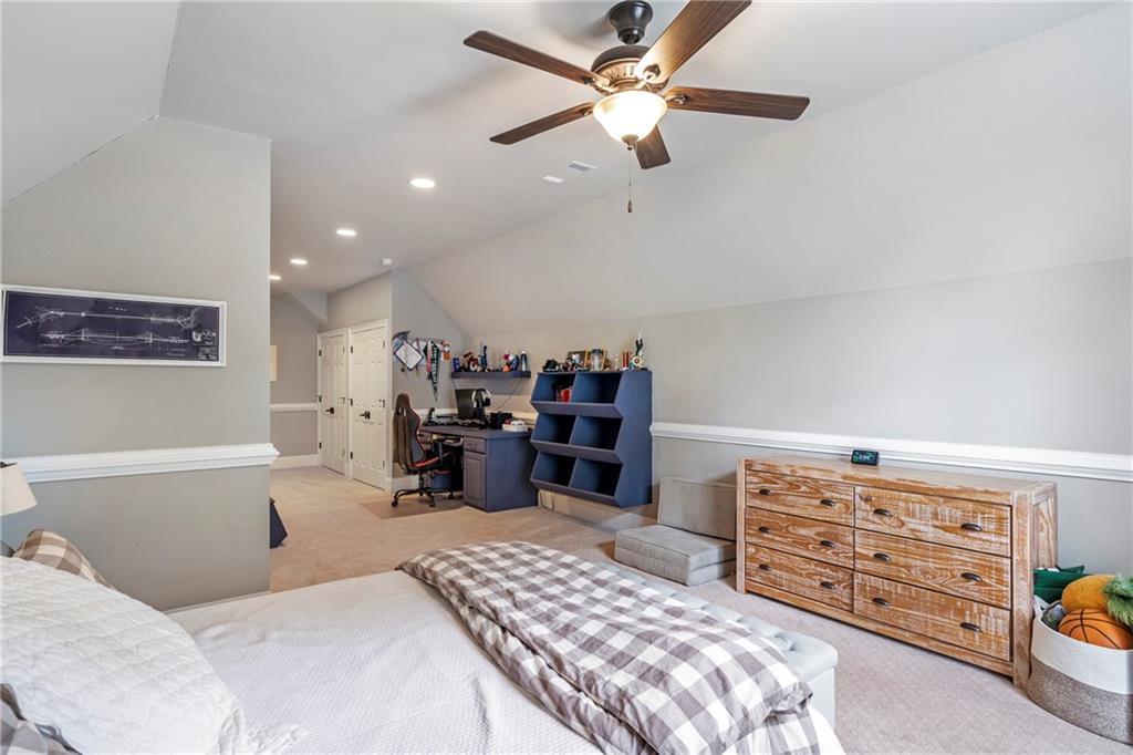 6026 GC Crow Road Flowery Branch, GA 30542 - Photo 69 of 100 a bed room with a bed and a chandelier