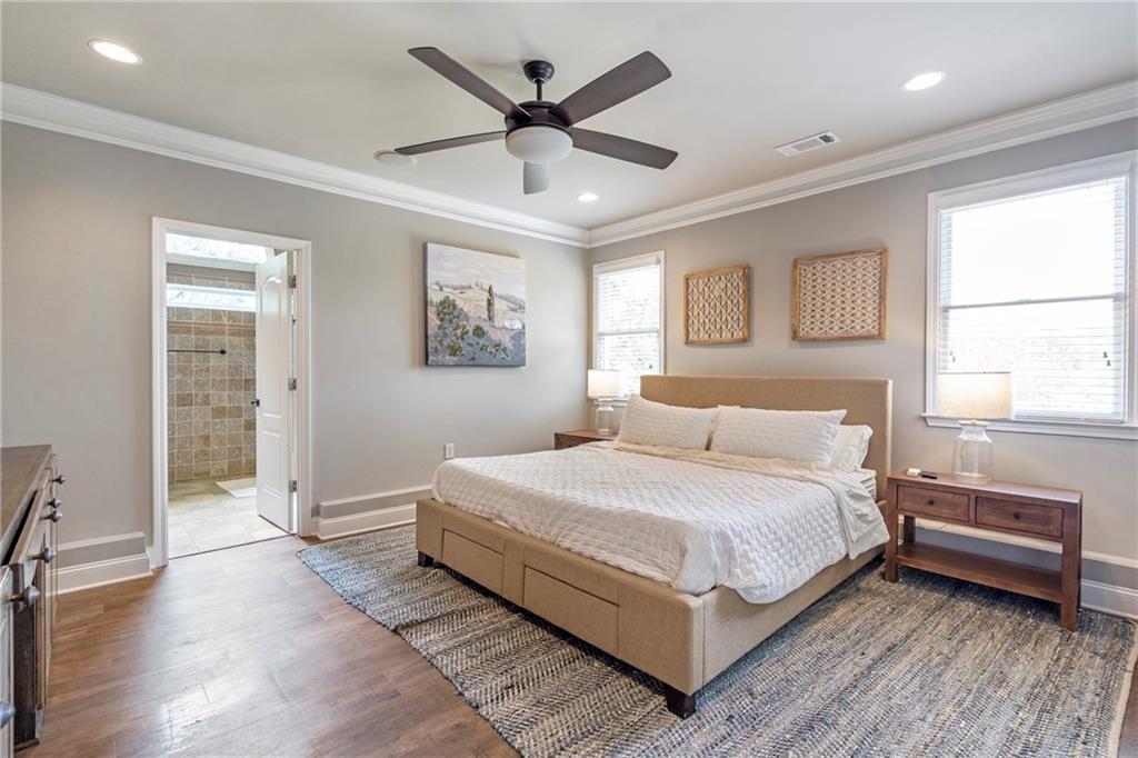 6026 GC Crow Road Flowery Branch, GA 30542 - Photo 75 of 100 a bedroom with a large bed and a ceiling fan