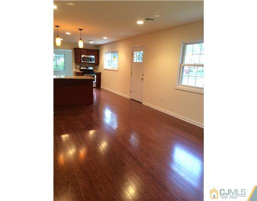 21 Stony Road Edison, NJ 08817 - Photo 4 of 23 a view of a living room with kitchen and wooden floor