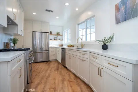 a kitchen with white cabinets and white stainless steel appliances