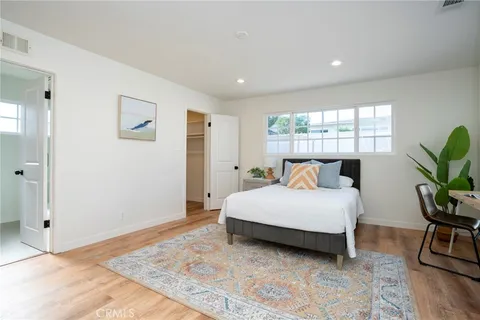 a bedroom with a bed lamp closet and window