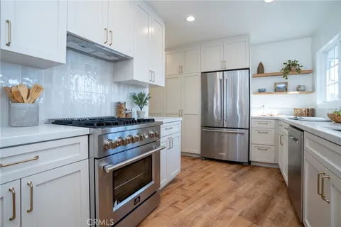 a kitchen with stainless steel appliances a stove a refrigerator and a sink