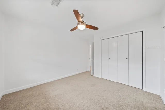 a view of empty room with ceiling fan